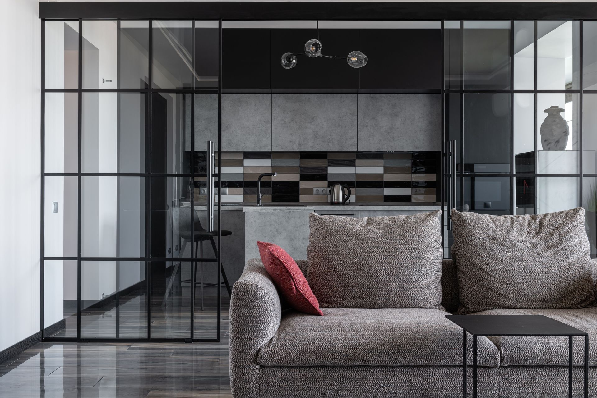 Contemporary living room with cozy sofa and open kitchen view.